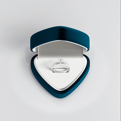 3D render design platinum diamond ring in open blue velvet jewelry box on white background, studio concept in jewelry store.