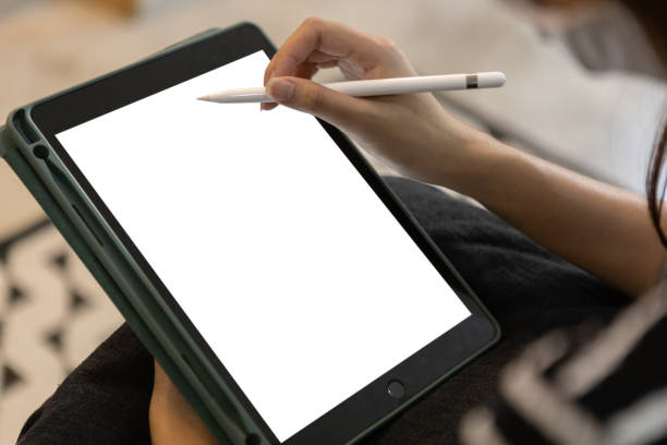 istock Female using digital tablet blank white screen on table meeting room.  woman working key touch display pad tablet. mockup for marketing add message and product advertisement. clipping path. 1500462947