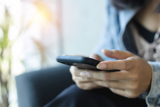 istock Close-up female hands using smartphone at table coffee cafe. chatting sending message online search social networks concept. communication cellphone digital telephone. 1500464028