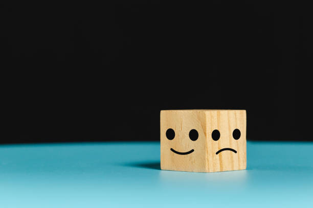 istock face emotion positive and negative concept. wooden cube with smiley face and sad face icon. satisfaction and service ranking. 1500464292