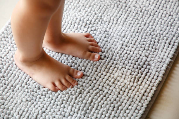 istock Child foots step on a gray doormat 1500465523