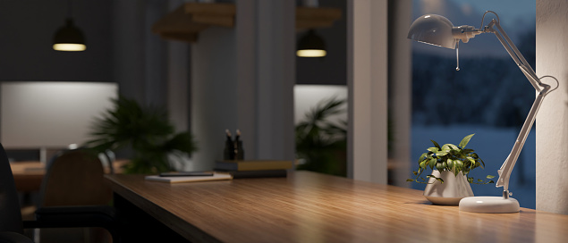 Close-up image of a copy space for your product display on a wooden table against the window with a table lamp in a modern dark office room at night. 3d render, 3d illustration