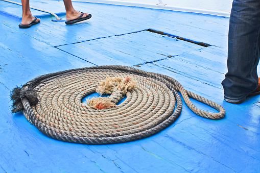 Ropes arranged in a circle on the deck of the ship with a photo of the passenger's feet next to it.