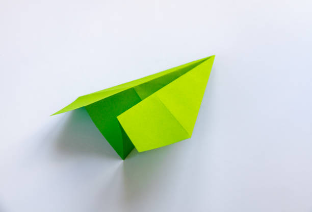 istock Green paper plane origami isolated on a white background 1500486094