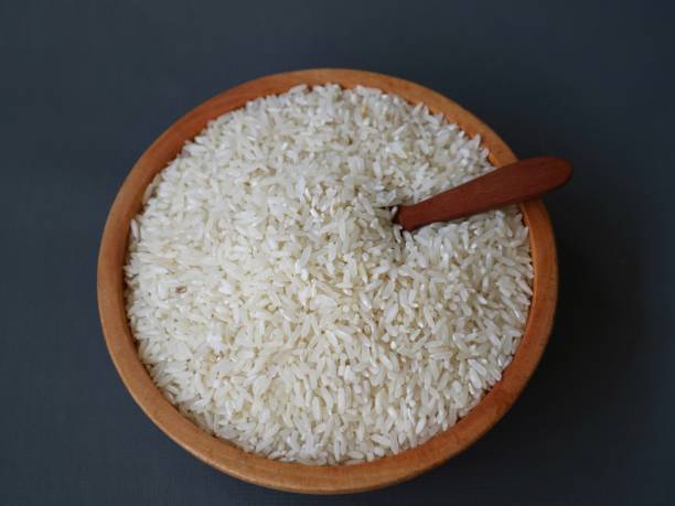 istock a bowl of rice grains on grey background. 1500487906