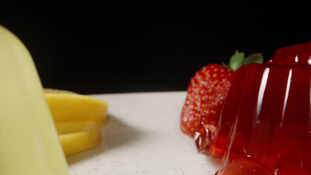 Strawberry and Lemon jelly on a white plate. Slices of Lemon and strawberry. Dolly slider extreme close-up.