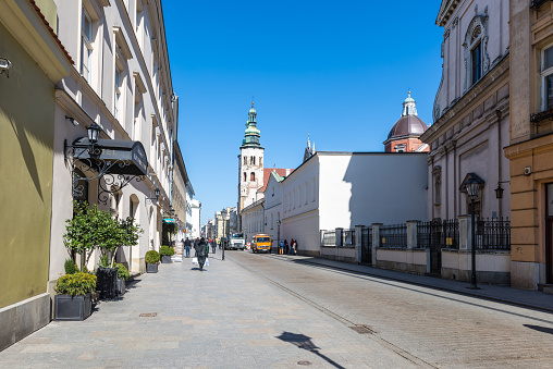 Krakow, Poland - March 11, 2022: Street view of Krakow at sunny day with hotel Balthazar in Poland. 5-star hotel on Grodzka Street in Old Town city center.