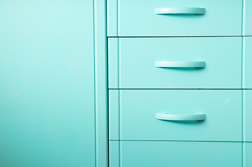 kitchen cabinet as background painted in turquoise color close-up, kitchen cabinet door