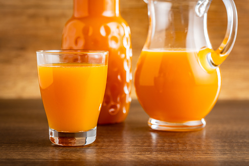 A glass of fruit juice. Orange  juice on the wooden table.