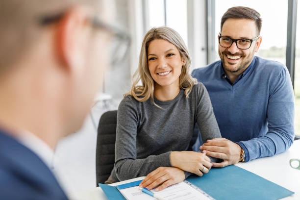 istock Happy couple talking to their agent in the office. 1500491240
