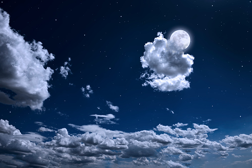Full moon rising over the cloudscape with copy space.