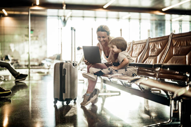 istock Happy single mother and son using laptop at departure area. 1500492588