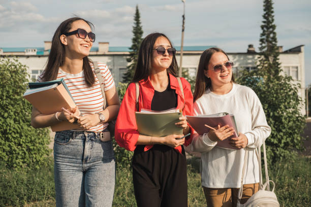 istock Happy students on university campus are resting after classes in summer sunny day, discussing homework. Selective focus. 1500492845