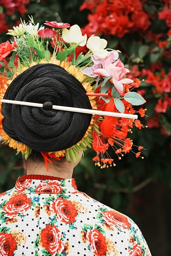 A female with an ornamental hairstyle and a floral headdress in traditional Chinese style.