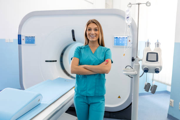 beautiful happy female doctor physician radiologist standing in ct cat scan room at hospital. - radiologist imagens e fotografias de stock