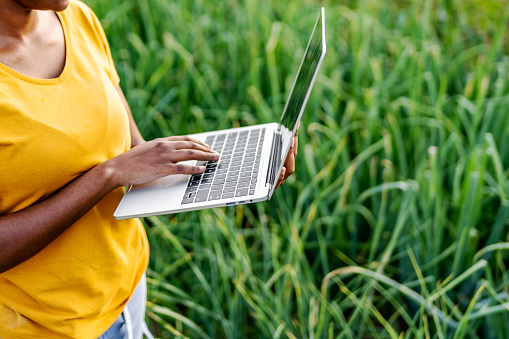 Farmer working in the field and using laptop to find an information