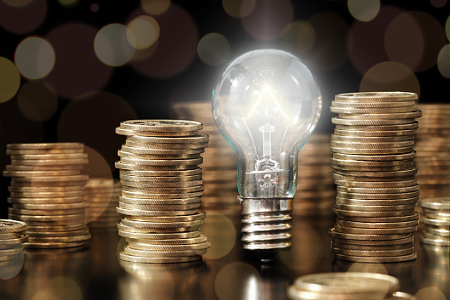 Lightbulb and stack of coins.