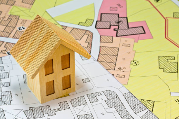 istock Construction industry and building permit concept with a residential area, cadastral map, General Urban Planning and wooden residential home model 1500503093