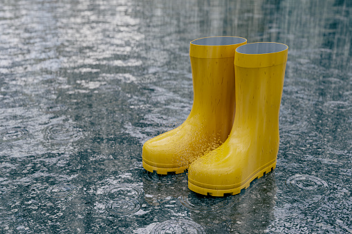 View of yellow boots on asphalt during heavy rain, 3d rendering