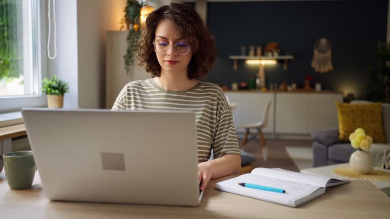 Young Caucasian woman working on laptop at her home office