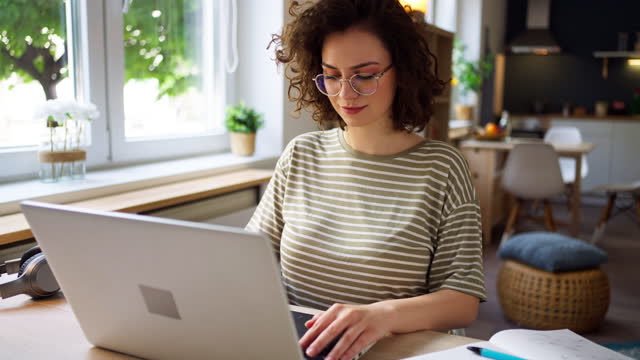Portrait of young Caucasian woman working on laptop at her home office