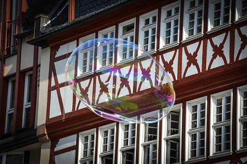 A colorful soap bubble among the typical facades of Frankfurt Old Town.