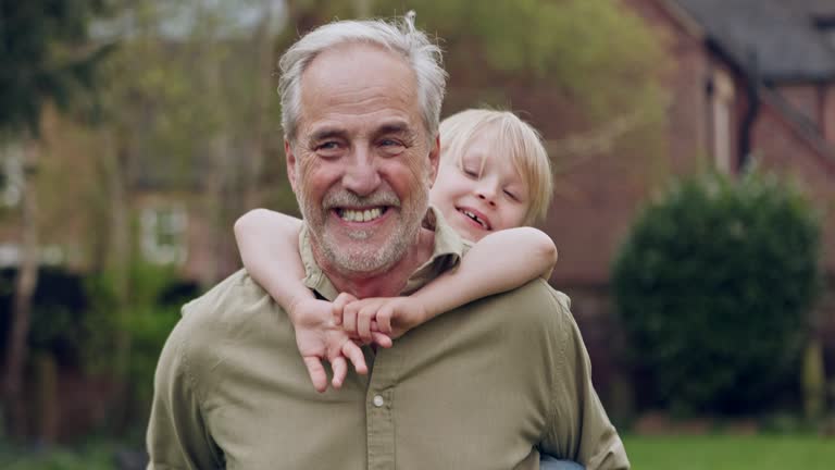 Senior man and grandson bonding together in a garden with fun and love. Playing, relationship and happy grandfather having family quality time