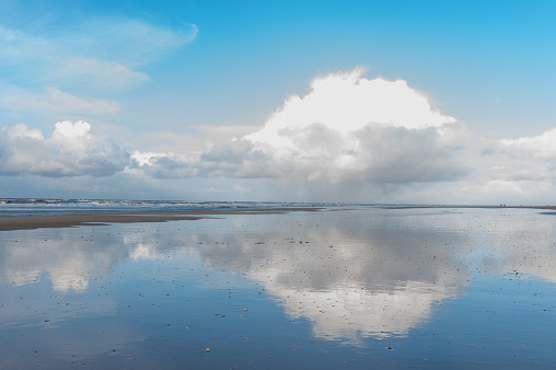 Clouds reflecting in a residu of water on the Beach near Egmond aan Zeen in North Holland, the Netherlands.