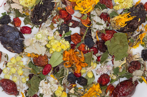 Herbal collection of dried leaves, flowers and fruits of the various wild mountain, forest and field medicinal plants on a dish, top view close-up
