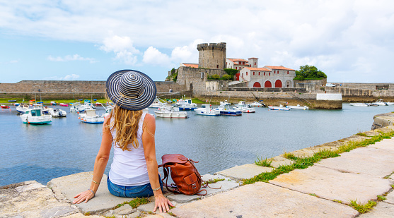Woman tourist in Ciboure castle and harbor, near Saint Jean de Luz and Biarritz- France