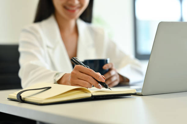 istock Cropped shot of female manager writing idea for startup project or reminder schedule note on notebook. 1500513383