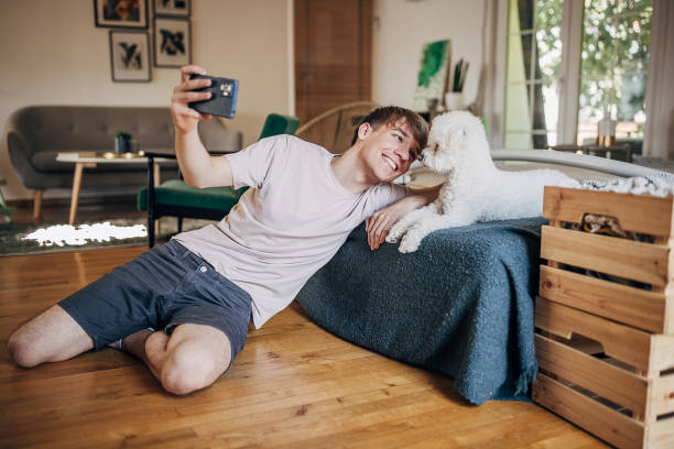istock Young man taking a selfie with his dog at home 1500517400