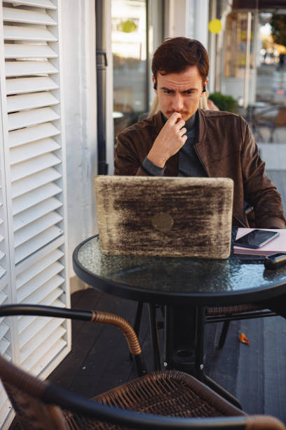 istock Businessman using laptop during freelance work in street cafe 1500519350