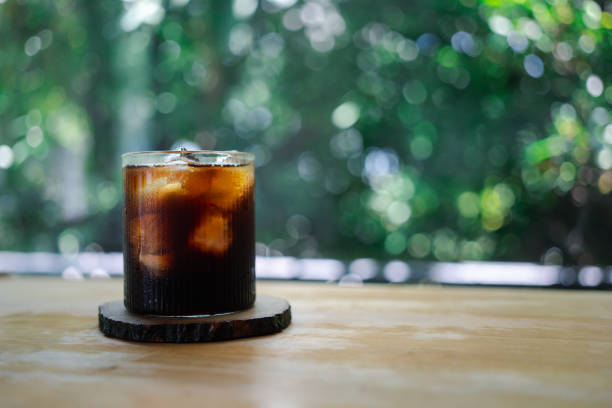 Ice coffee in a glass on a nature background. Ice coffee in a glass on a nature background. Cold summer drink with copy space cafe transparent glass table stock pictures, royalty-free photos & images