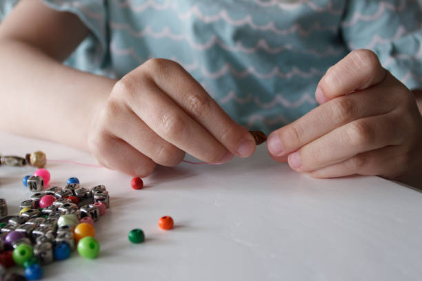 istock Process of making a bracelet from a thread and colored beads, concept of hobby 1500521294