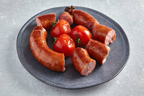 istock Fried pork sausage cut into pieces in a gray plate with tomatoes 1500521652