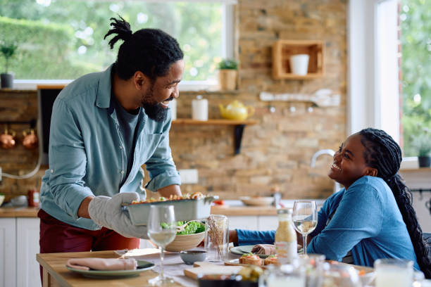 istock Happy black man serving lunch to his wife at dining table. 1500523890