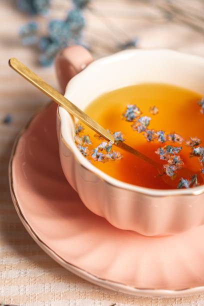istock Elegantly designed pink ceramic tea cup placed on a white marble table with dried blue flowers 1500524052