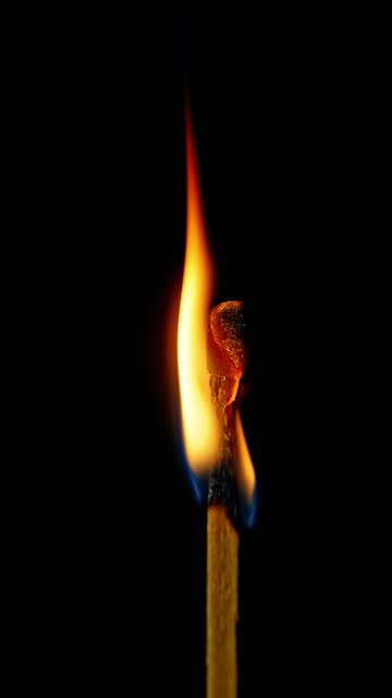 Vertical video of Match burning against a black background