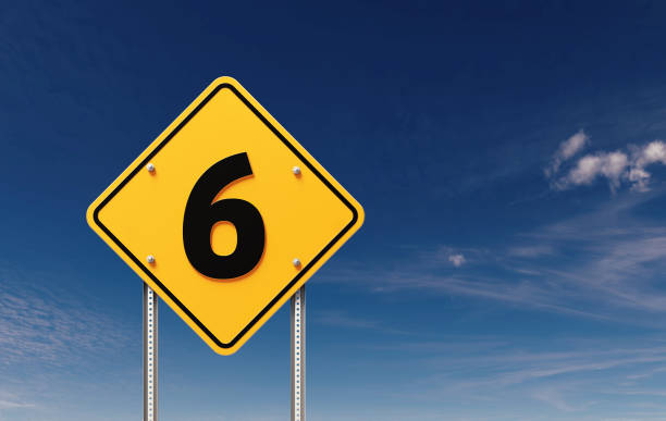 Number 6 written yellow off road traffic sign before blue sky. Horizontal composition with copy space.