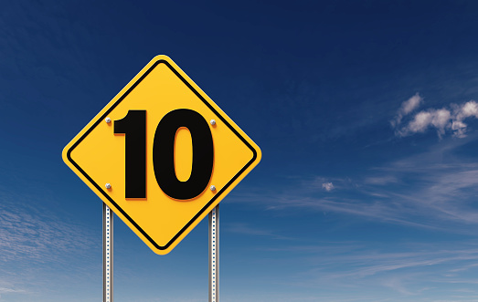 Number 10 written yellow off road traffic sign before blue sky. Horizontal composition with copy space.