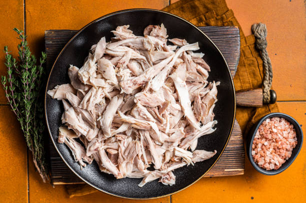 istock Shredded chicken meat in a plate. Orange background. Top view 1500530854