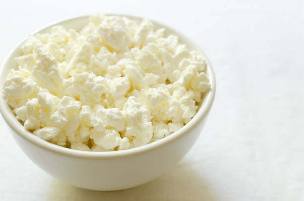 istock Organic cottage cheese in a white ceramic bowl on a white tablecloth. Healthy breakfast. The concept of homemade food. Coopy space. Selective focus. Horizontal orientation. 1500536655