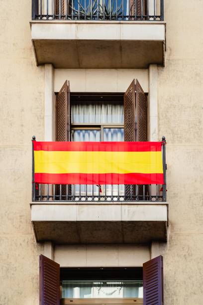 istock a yellow and red striped flag hangs above a doorway that is open with shutters 1500538339