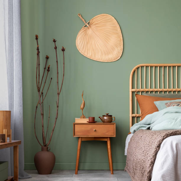 istock Elegant bedroom interior design with bamboo bed, modern bedclothes, night table and stylish accessories. Eucalyptus wall. Template. Copy space. 1500540051