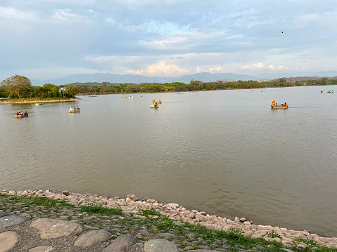 Stock photo showing view from bank of Sukhna Lake, Chandigarh, India. Boating on the popular reservoir is a popular tourism activity on this migratory bird sanctuary that the  Government of India have declared a protected national wetland.