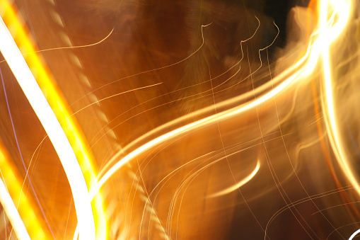 Stock photo showing blurred orange lights at night, depicting fast movement captured with long exposure.