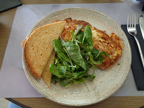 An omelette with green salad served in a restaurant