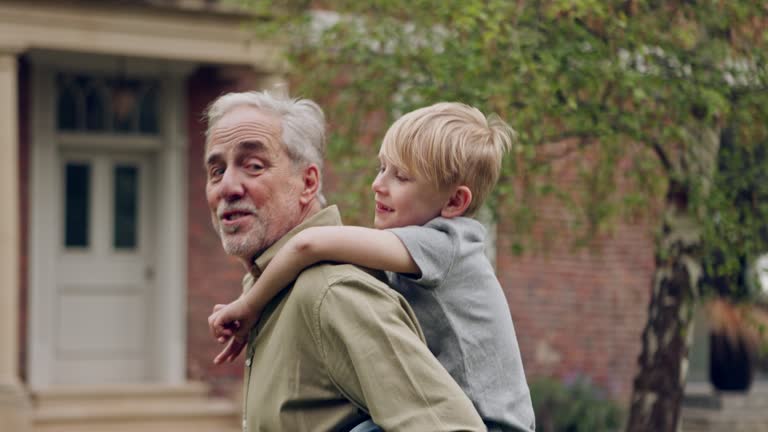 Senior man and grandson bonding together in a garden with fun and love. Playing, relationship and happy grandfather having family quality time