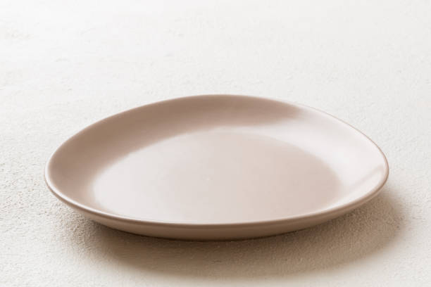 istock Perspective view of empty light plate on cement background. Empty space for your design 1500560422
